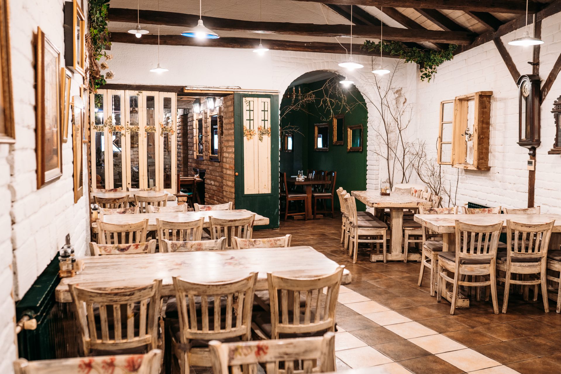 Blagovaonica restorana Lamut sa zelenim vratima i drvenim stolovima